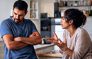 Dispute dans la cuisine : elle parle, il croise les bras et détourne le regard
