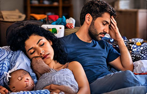 Des parents épuisés : elle endormie avec le bébé, lui la tête dans la main